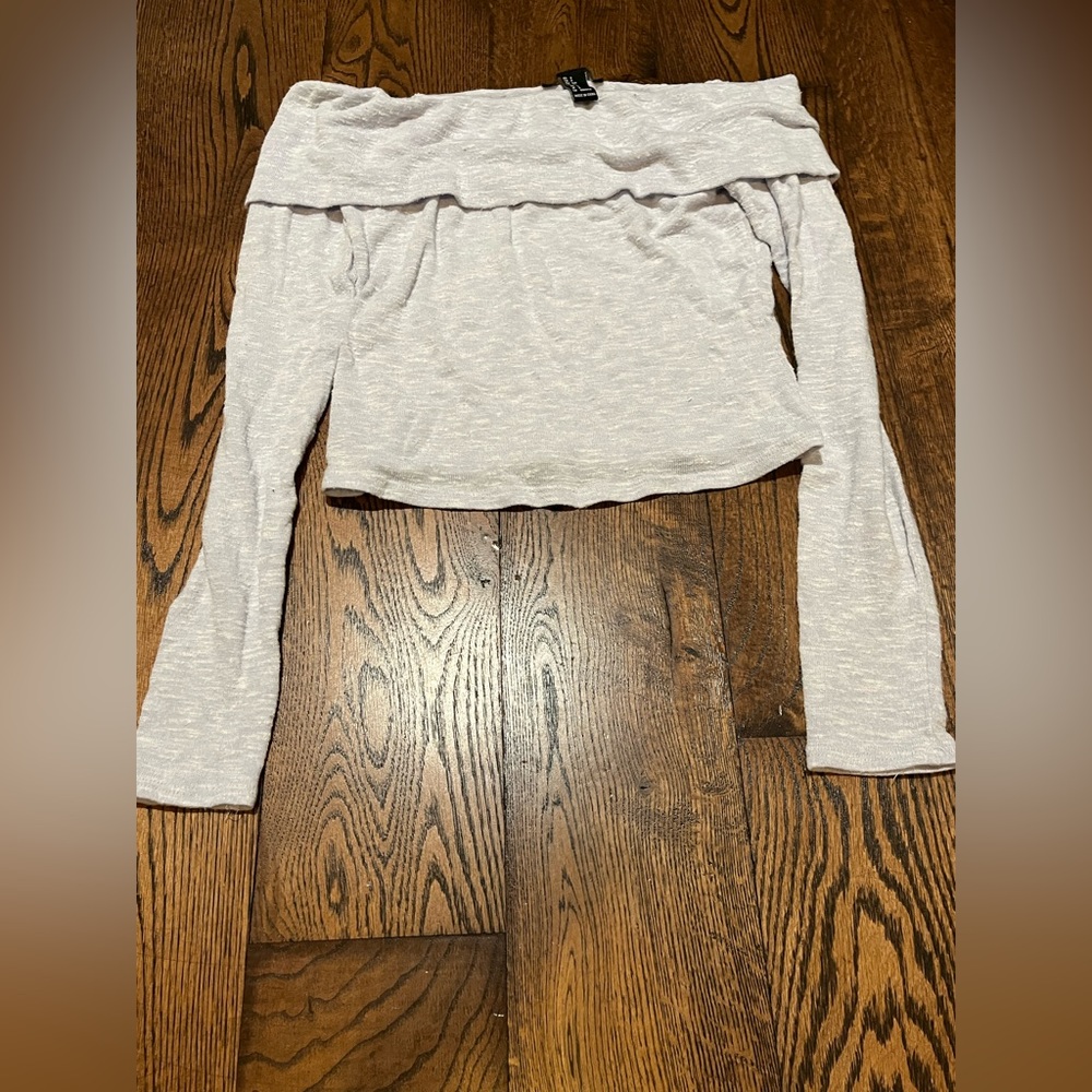 A whitish purple, long sleeve shirt with folded shoulders